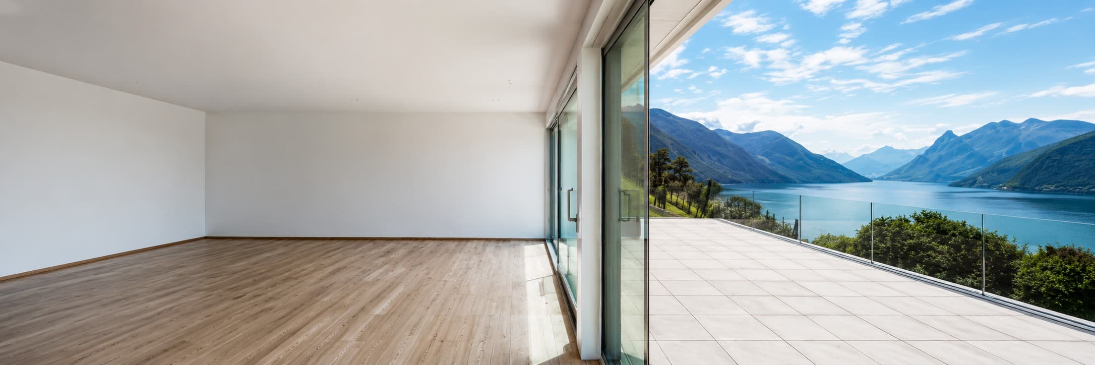 Leere, helle Wohnung mit grossen Fenstern und Holzboden